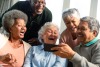 group of older adults looking at something on phone and laughing
